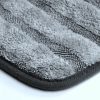 Close up of a striped high pile and low twisted loop light grey microfiber towel edge with smooth darker grey edging