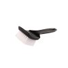 Black plastic brush with white nylon bristles lying on the bristled side