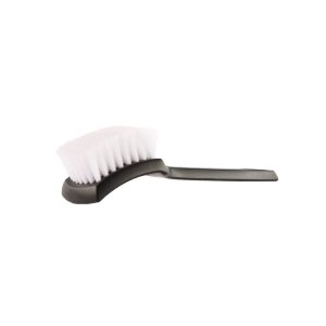 Black plastic brush with white nylon bristles lying on its back with bristles up