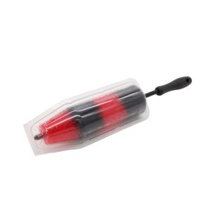 Bristle bottle brush in red and black with black handle sitting inside a rigid transparent plastic casing.