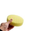 Front side of yellow recessed diamond foam pad being held by a hand.