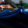 Close up of hand cleaning car bonnet with a blue plush microfiber cloth by Ewocar.